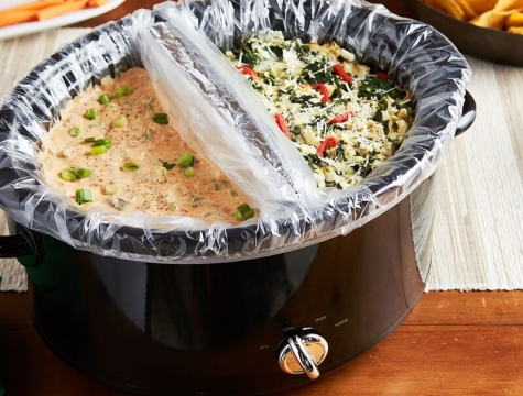 slow cooker divided in half and lined with slow cooker liners that are filled with two different dips