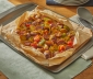 breakfast hash with melted cheese sitting in an open parchment cooking bag