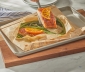 person lifting a salmon filet from an open parchment cooking bag
