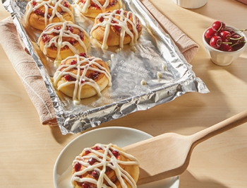 Cinnamon rolls sitting on a foil lined baking sheet